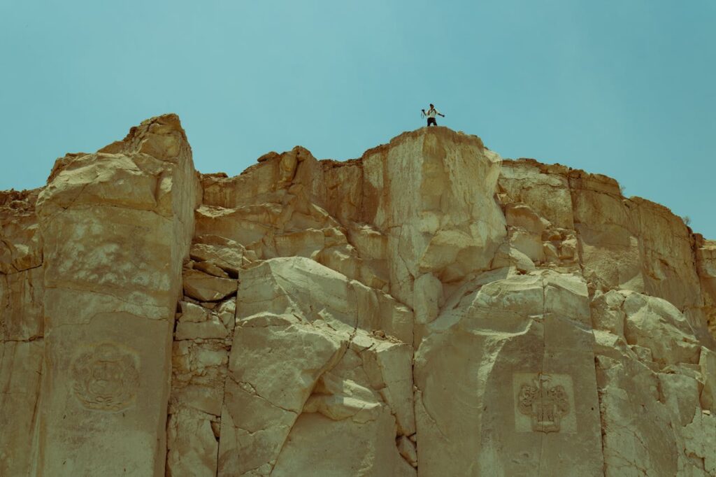 A person standing on top of a rock formation